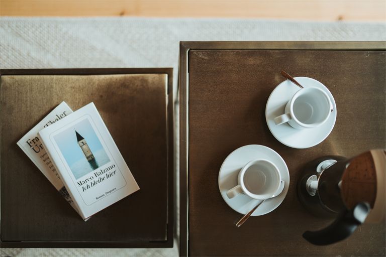 Wohnzimmertisch mit Büchern und Espressotassen in Apartment 1 auf dem Dornerhof in Meran